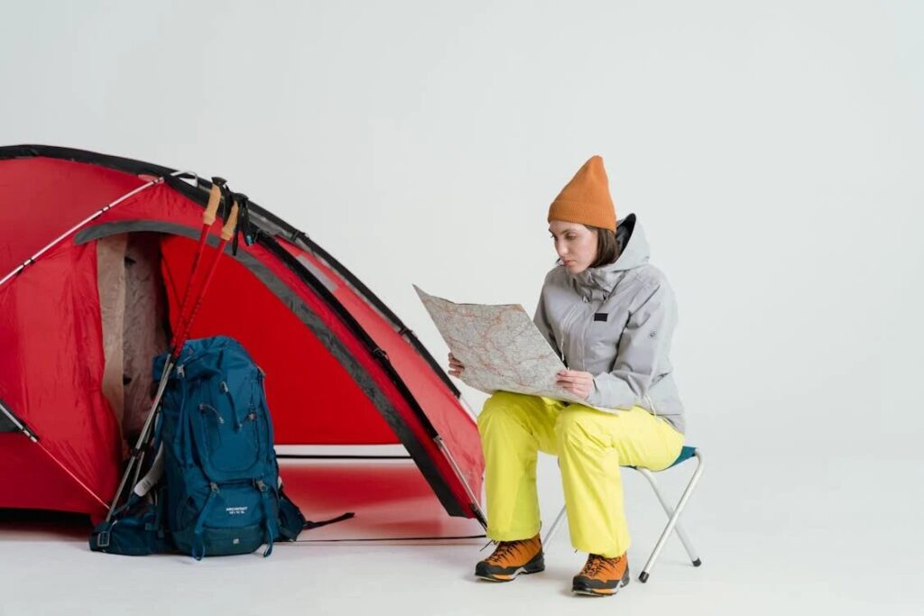 A Girl Watching Map Next To Tent