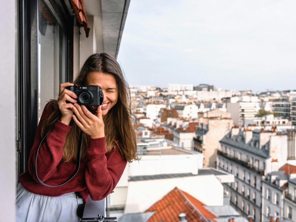 Woman standing on a building and capturing photo