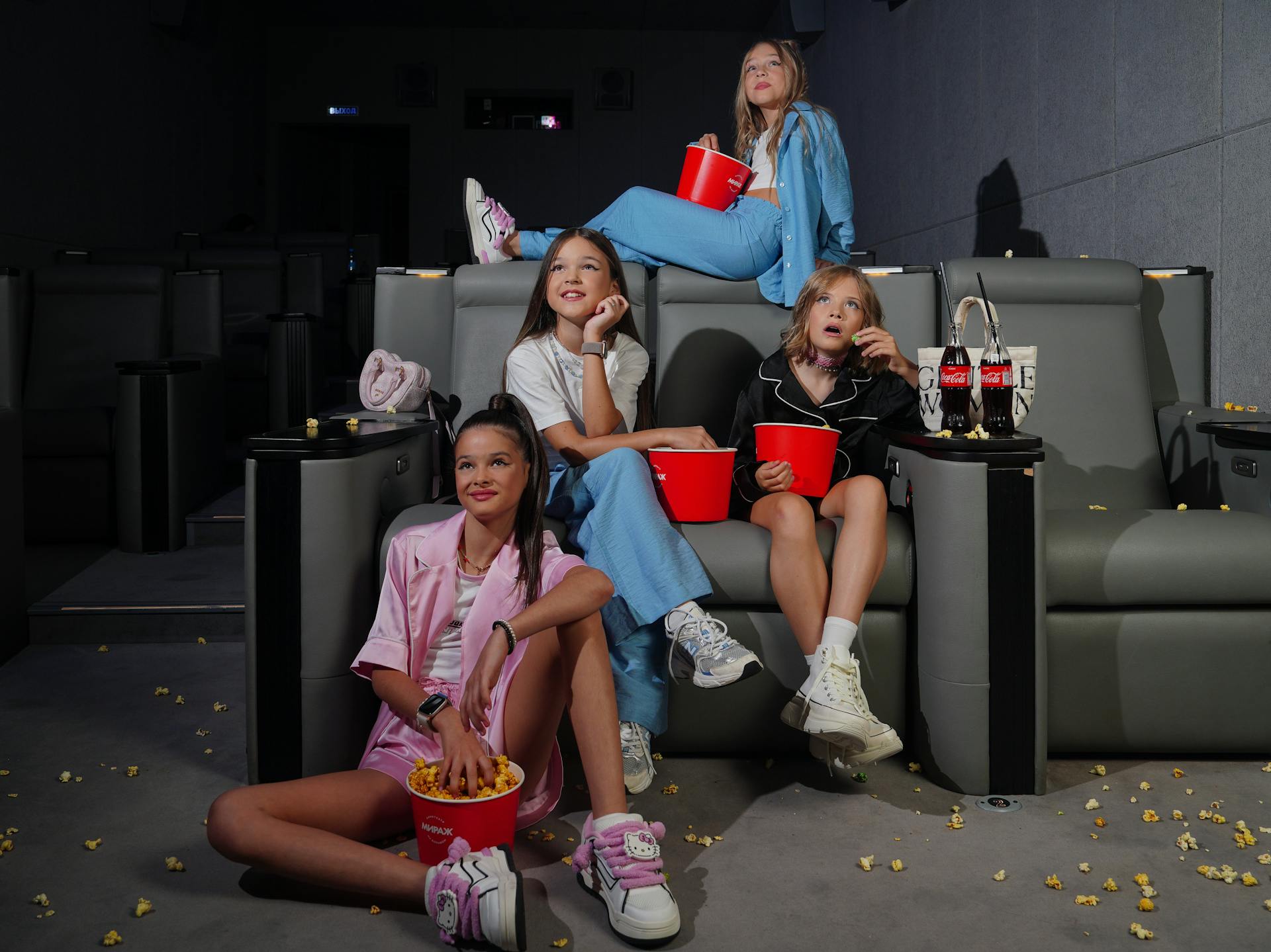 Girls Sitting On Theater Seats With Food Trays And Drinks Inside A Dine-In Movie Theater In Chicago