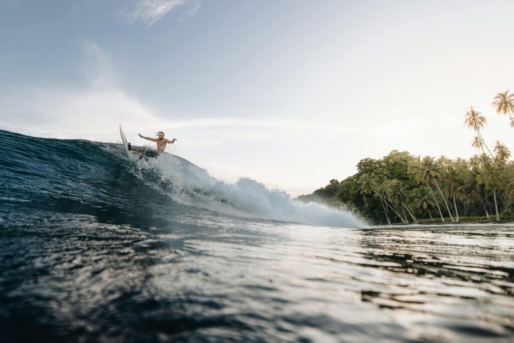A Tourist Enjoying Surfing Activities At Seminyak Beach In Bali, August